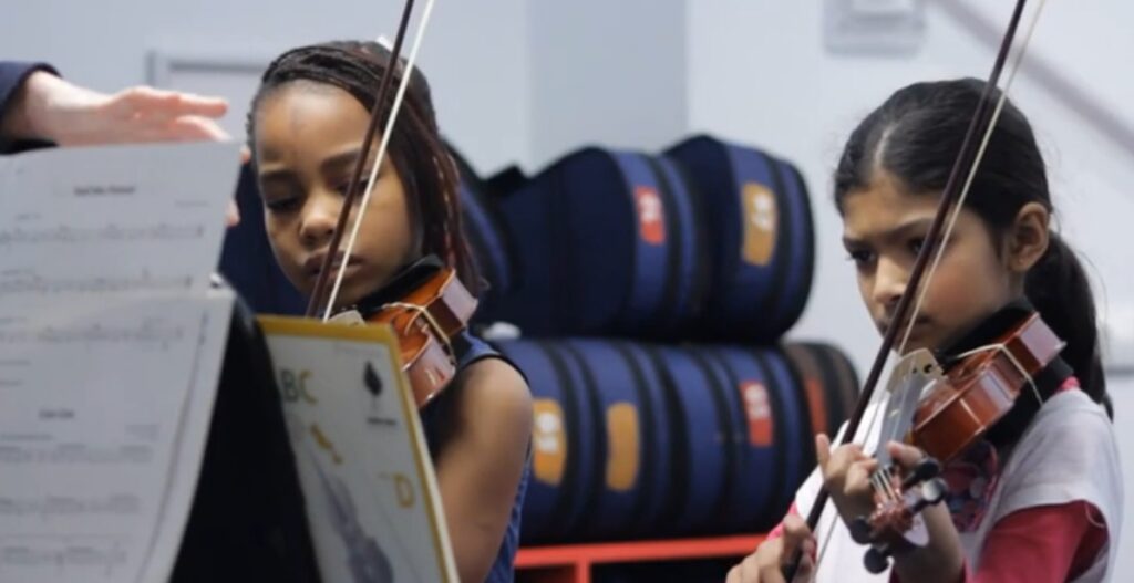Girls concentrating in violin lesson